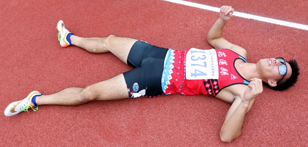  楊俊瀚跑完千六接力，直接躺在跑道上休息。林嘉欣／攝影。