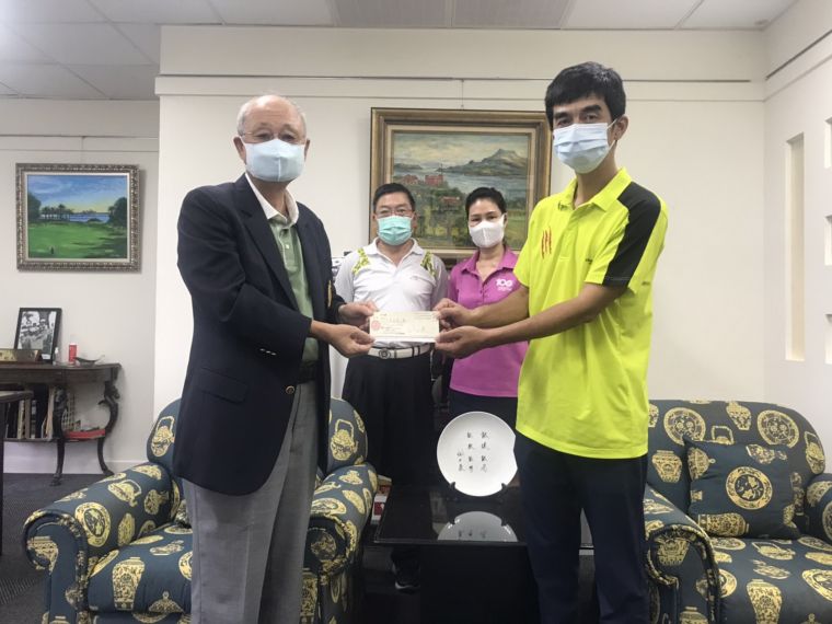 台灣高爾夫俱樂部會長紀文豪(左)以個人名義提供300萬元無息貸款給球場全體桿弟,由桿弟代表謝志偉接受。後左為桿弟管理組長王聲起丶後右為副理呂麗還。官方提供