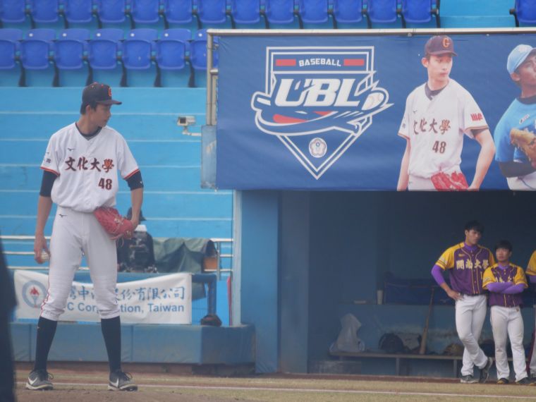 文化投手林振瑋站在自己的巨幅海報前出賽。吳敏欣攝