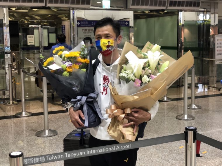 教練曾自強雙手各捧一束花,其中一份是他代林郁婷收下。官方提供