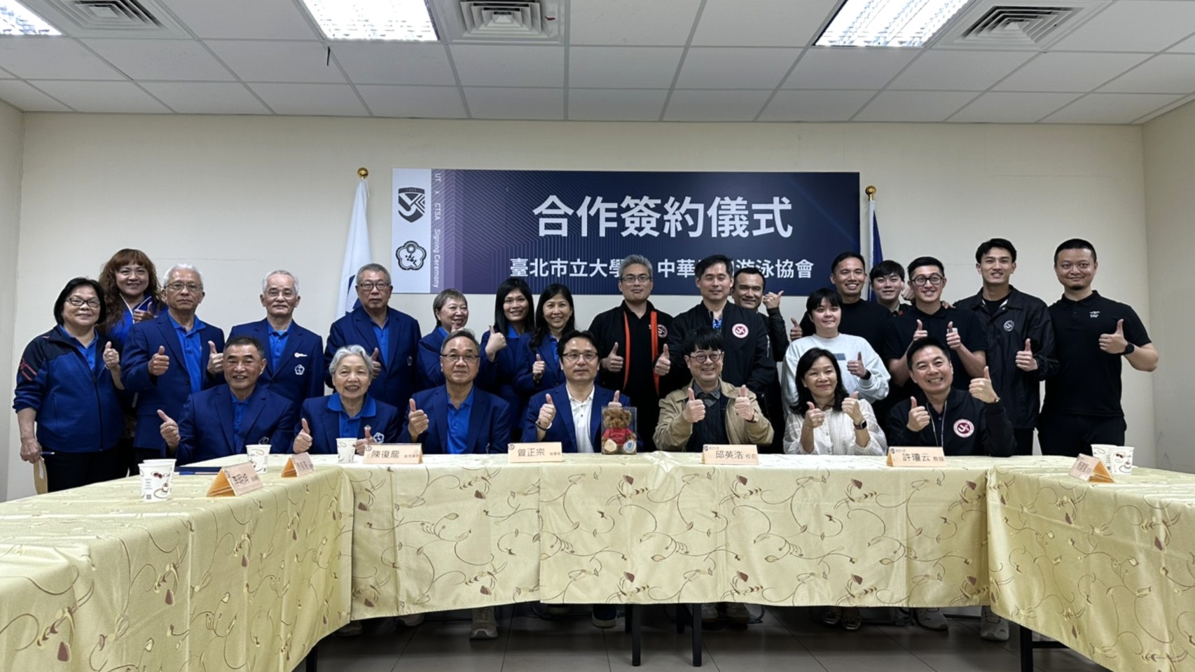 臺北市立大學校長邱英浩與中華民國游泳協會秘書長曾正宗在北市大詩欣館競賽池畔共同簽署合作協議，來賓合影留下紀念。中華民國游泳協會提供