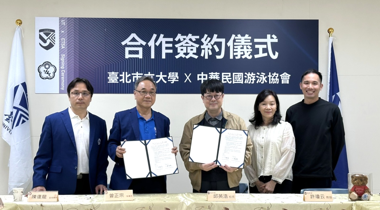 中華泳協副理事長陳復龍與北市大校長邱英浩代表雙方簽屬並交換協議書，(左起)泳協秘書長曾正宗、泳協副理事長陳復龍、北市大校長邱英浩、北市大水上運動學系教授許瓊云。中華民國游泳協會提供