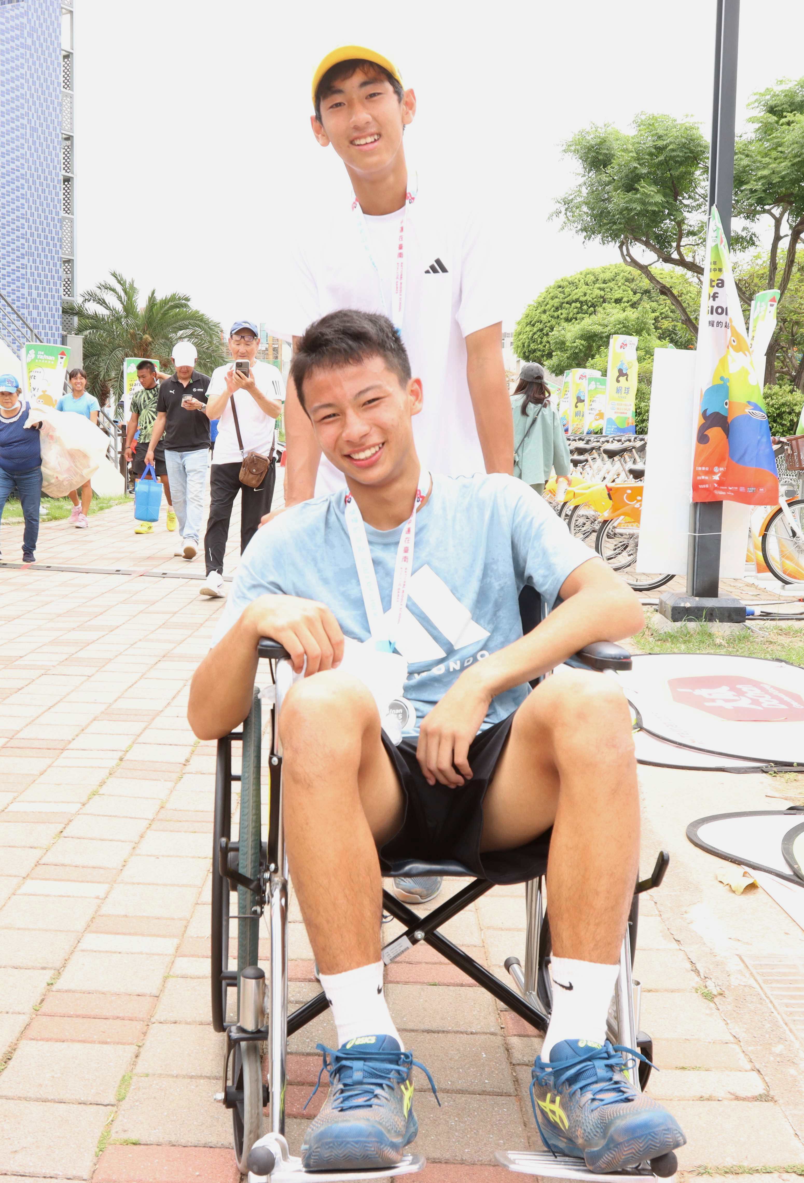 頒完獎後，國男單金牌黃韋博推著坐在輪椅上的銀牌陳宏軒前往休息區。四維體育推廣教育基金會提供