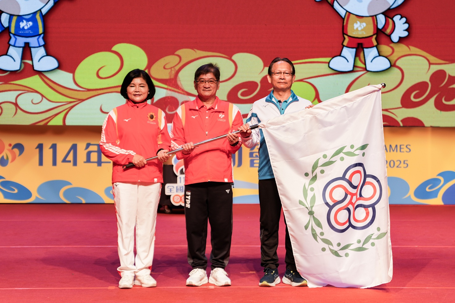 在運動部次長洪志昌(中)見證下 雲林縣長張麗善(左)將會旗交棒下屆主辦屏東縣楊慶哲秘書長。籌備處提供