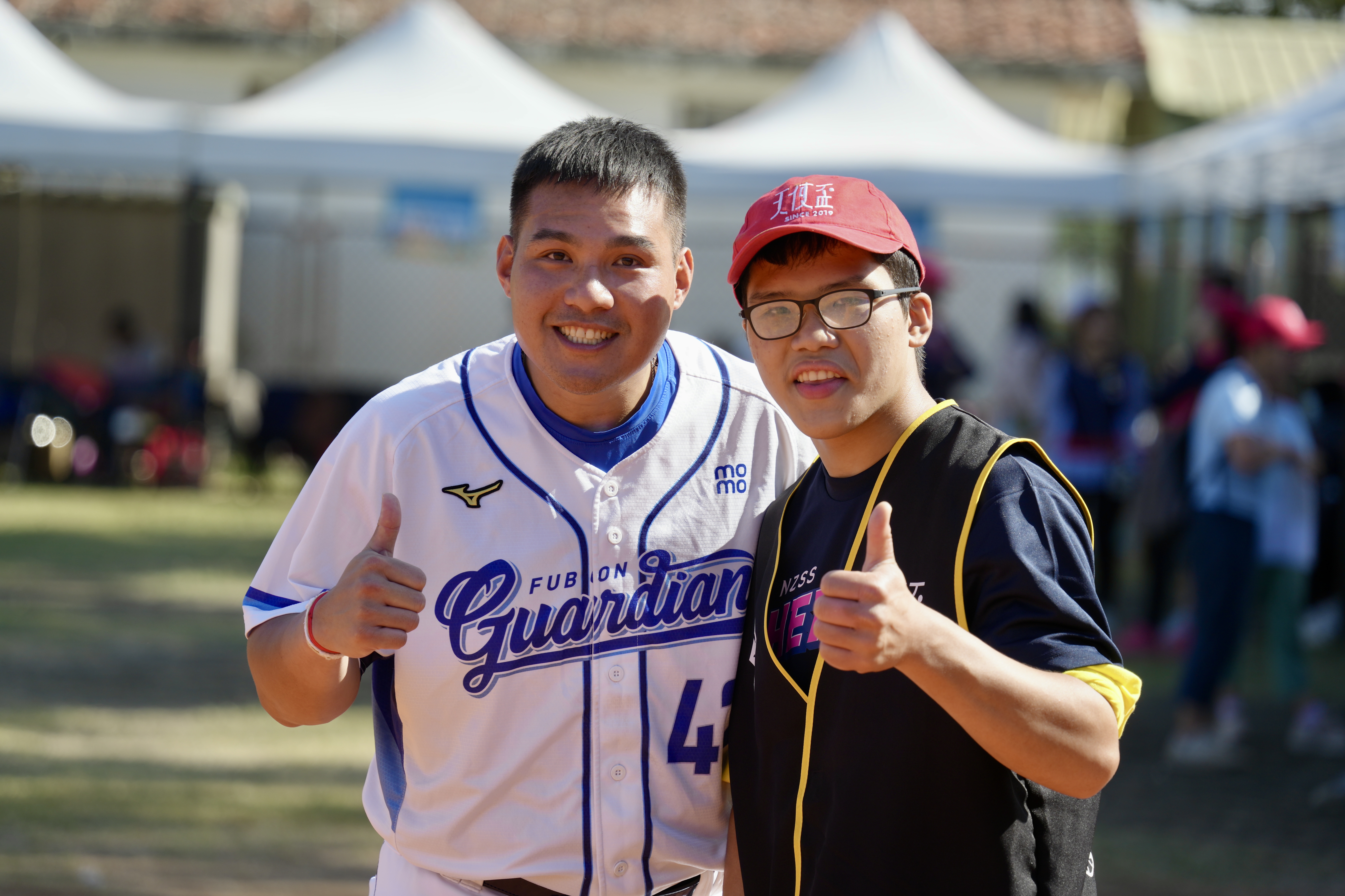 張進德（左）在選手站上一壘後主動合影留念。大會提供