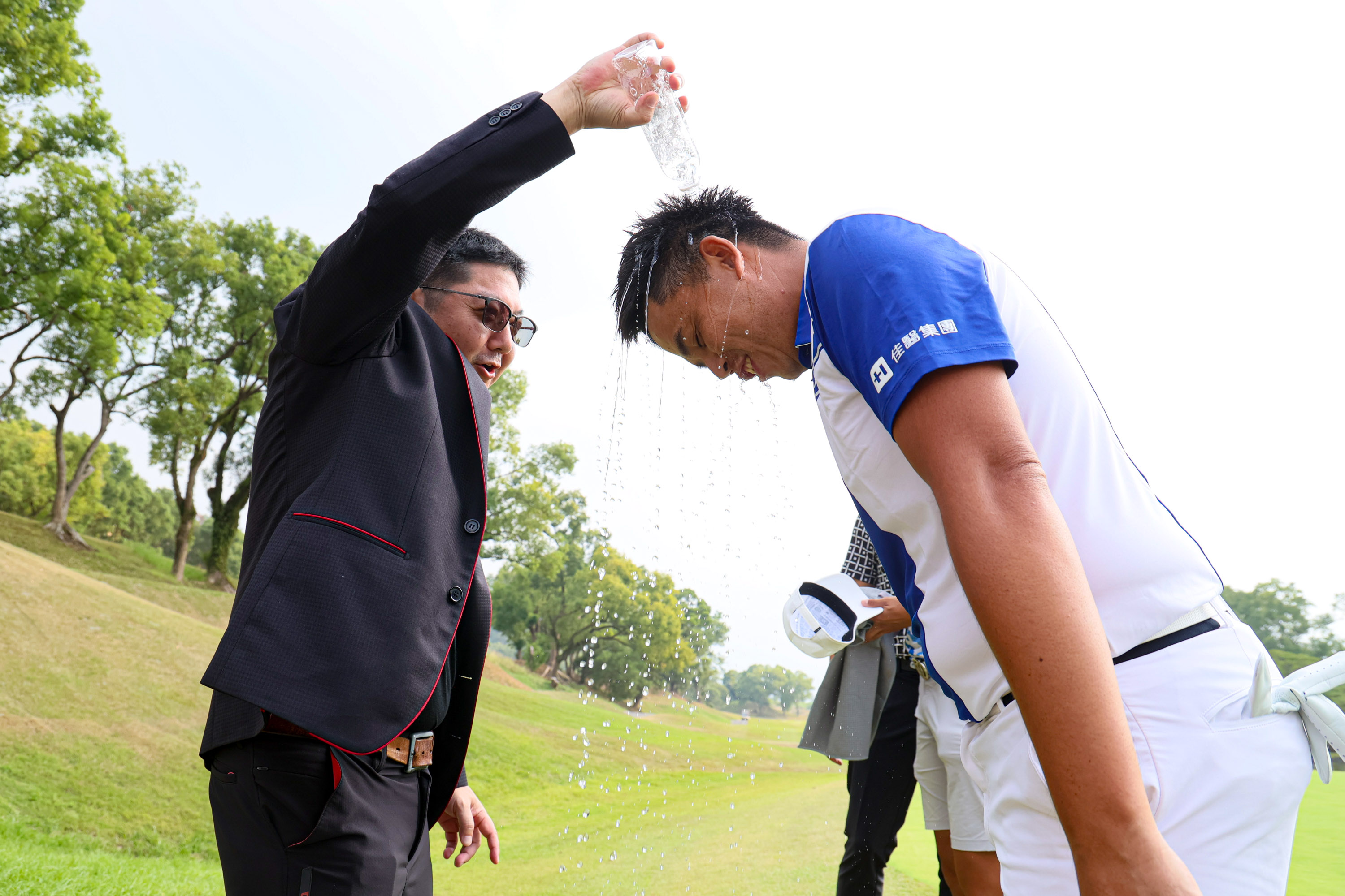 Kbs Taiwan董事長莊宇龍左在18洞為冠軍選手洪健堯潑水慶祝。KBS公開賽提供