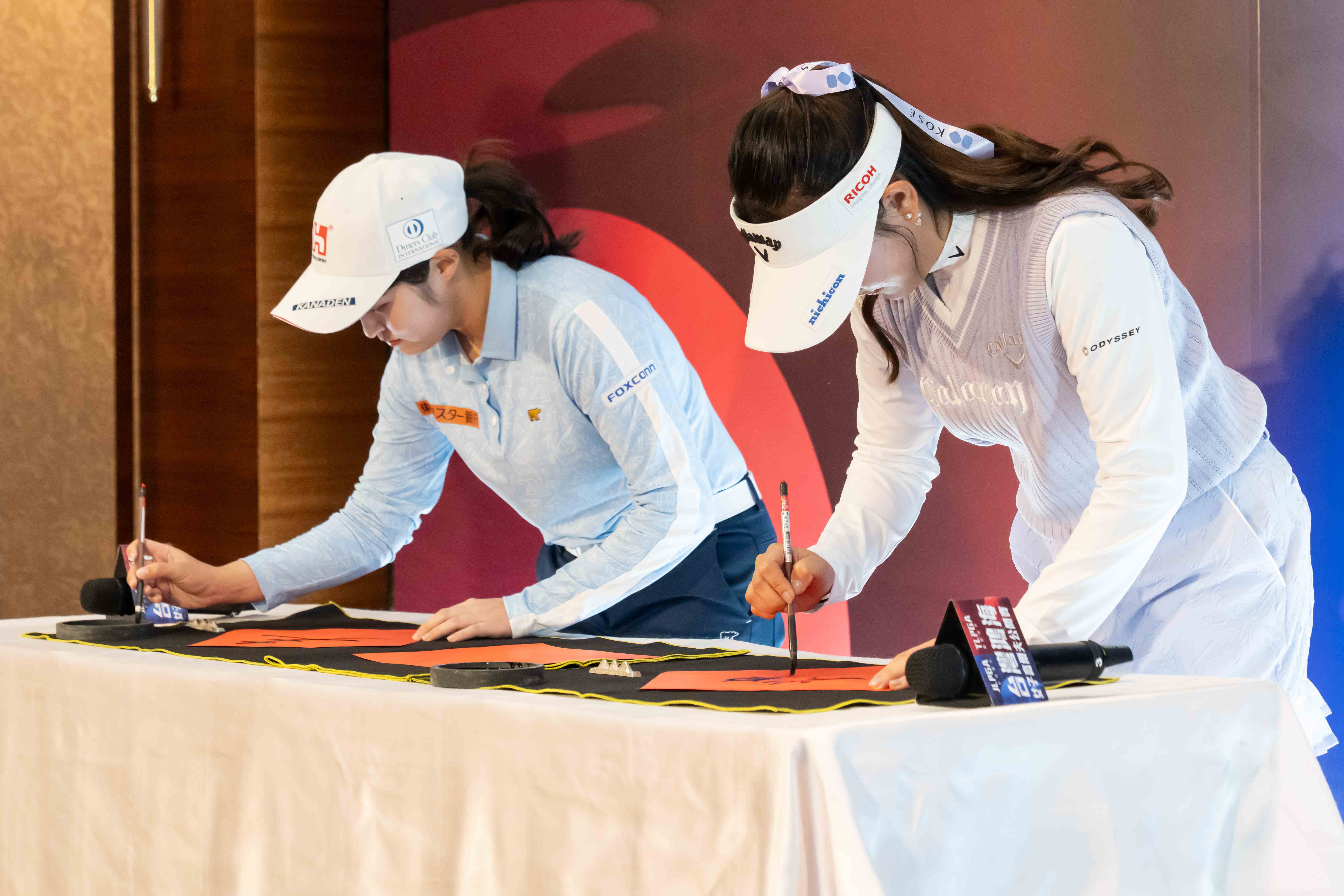 鴻海贊助選手吳佳晏及日本選手絲帶女孩河本結一同寫下年度代表字。大會提供