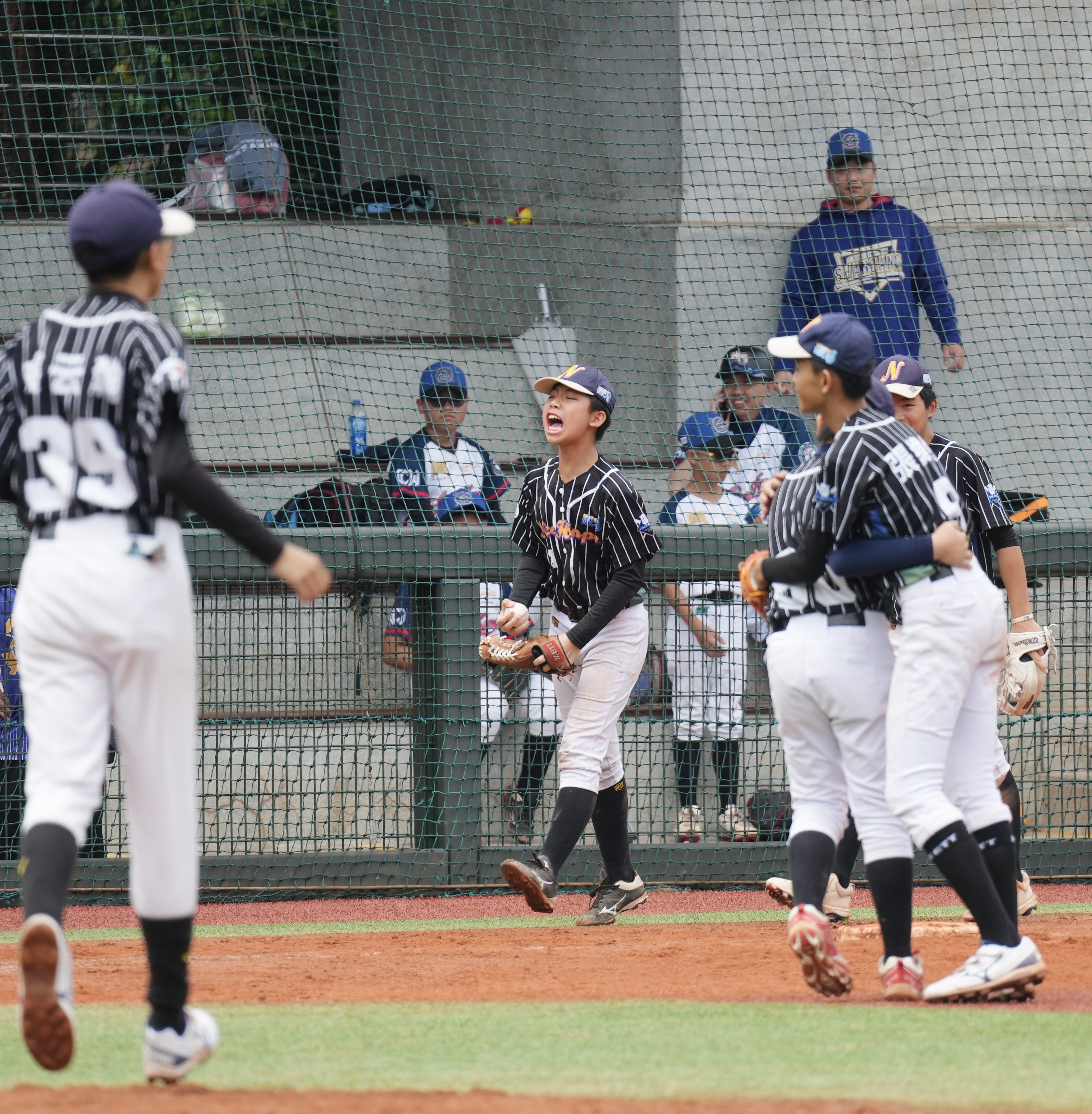 石景筌(中)完成再見美技接殺，起身後興奮地大叫慶祝。臺灣世界少棒聯盟提供