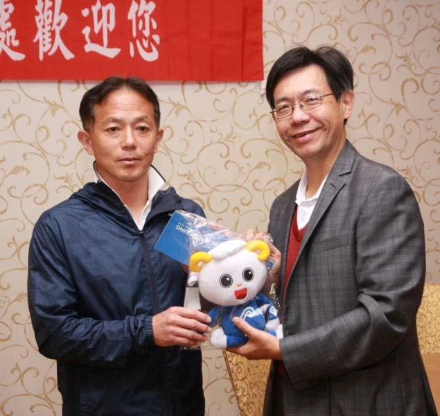 高雄市體育處處長黃煜（右）贈浦田秀明紀念品。高雄市體育處提供