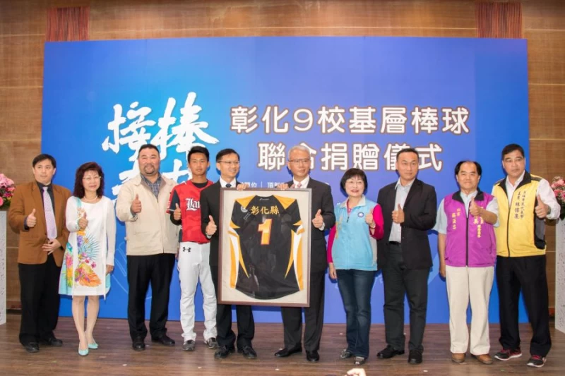 彰化縣教育處處長鄧進權代表彰化縣政府致贈彰化縣一號球衣予頂新和德文教基金會董事長魏應充,象徵基金會是彰化縣政府的一號隊友。圖/頂新和德文教基金會提供