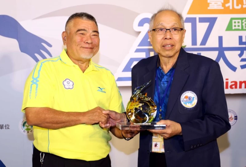 田徑協會副理事長翟學電，致贈琉璃藝品予亞洲田徑總會代表Loh Lin Yow。林嘉欣／攝影。