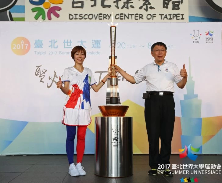 火炬手陳詩欣將聖火傳給柯市長，並在臺北市政府一樓駐火。台北世大運執委會提供