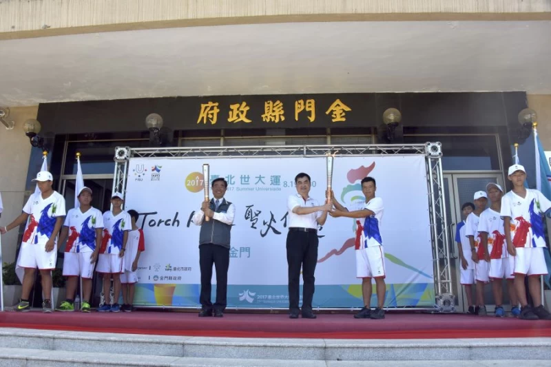 台北市副市長鄧家基率台北火炬手陳銘傳(2007曼谷世大運高球金牌)交接給金門縣副縣長吳成典。台北執委會提供