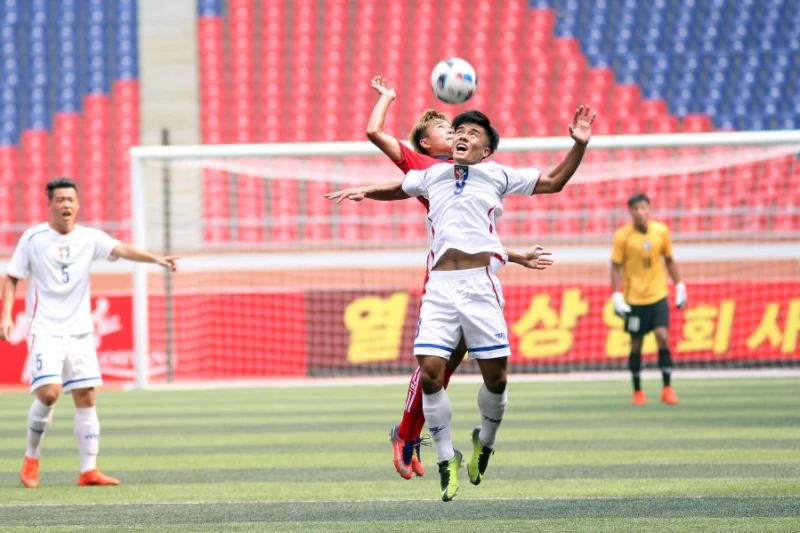 中華隊江信隆(右)與對方爭頂,中華民國足球協會提供