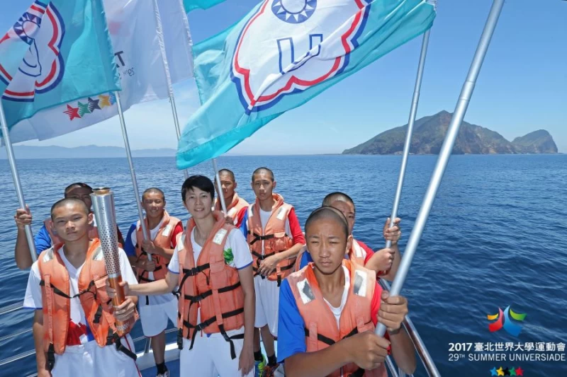 13位宜蘭縣礁溪國中排球隊選手擔任火炬手及護火隊,與臺北火炬手-桌球選手陸雲鳳進行海上傳遞。台北世大運執委會提供