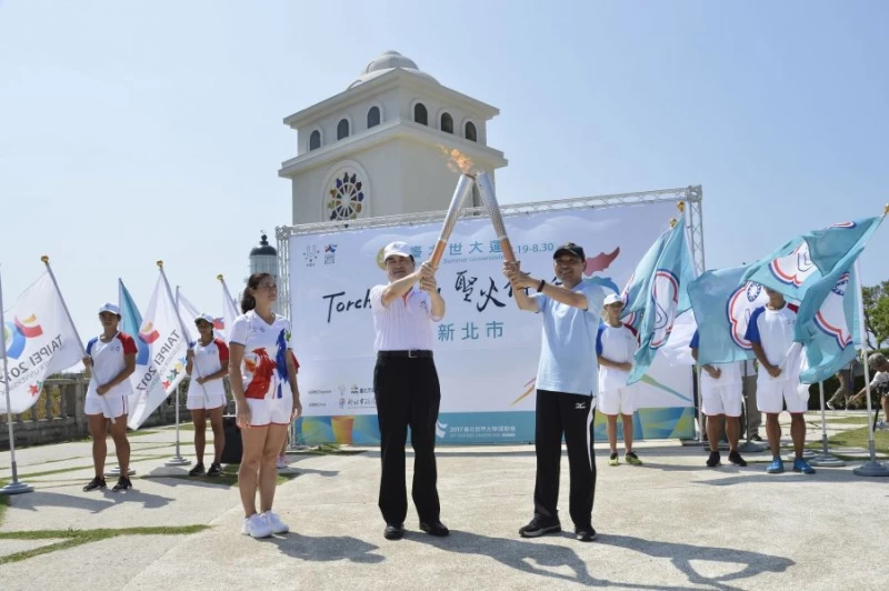 台北市鄧家基副市長於臺灣極東三貂角燈塔將聖火點燃給新北市侯友宜副市長。台北世大運執委會提供
