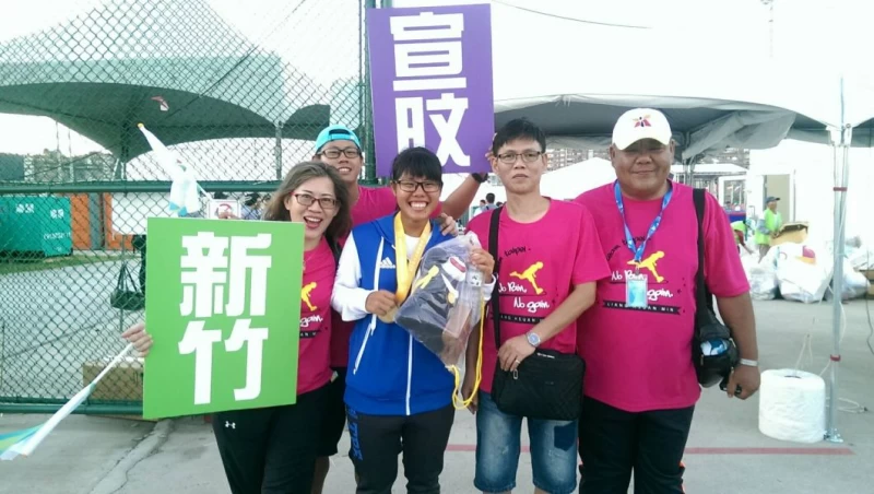 中華隊女子滑輪溜冰選手梁宣旼（藍衣）在奪金後與家人及教練（右二）合影。台北世大運組委會提供