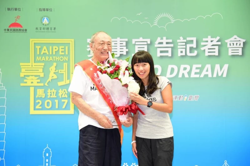 由陳宇璿(右)代表臺北馬拉松選手送上花束,感謝吳家善多年來對臺北馬的用心。(主辦單位提供)