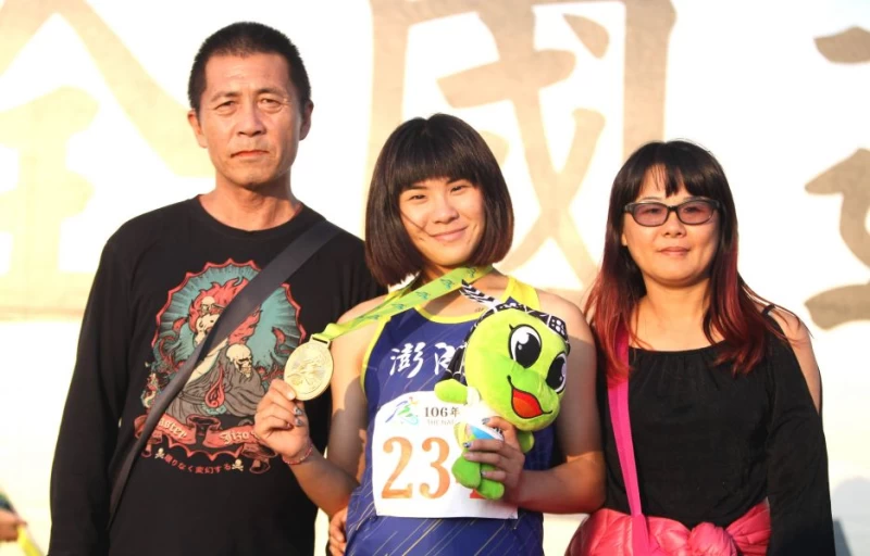 劉亞君(中)終於在跳遠拿到盼了六年的全運首金,開心和雙親合影。林嘉欣/攝影。