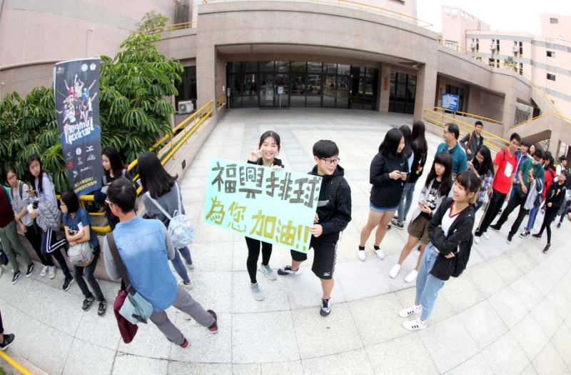莊珮柔和同學特製「 福興排球為您加油」海報，為企排球星加油！林嘉欣／攝影。