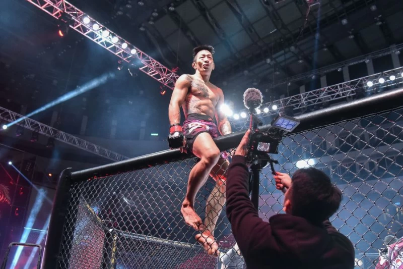 曾登上UFC的台灣選手李俊翰戰勝日本選手今村豐,興奮地跳上鐵籠慶祝。中華民國綜合格鬥協會提供