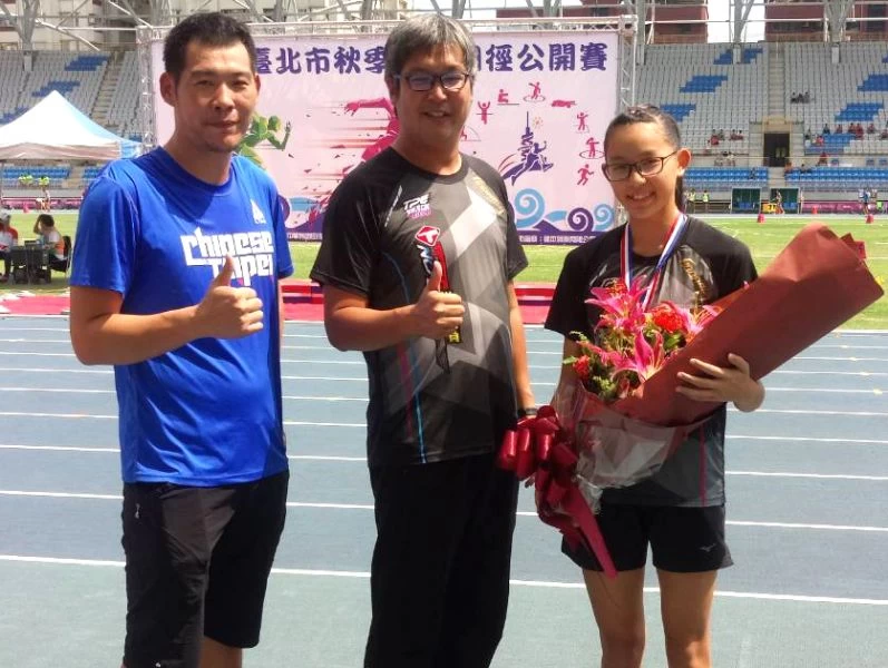 張嘉妤成為芎林國中史上首位田徑國手,教練鍾彩榮(中)和指導她跳高的陳鴻傑(左)都替她高興。鍾彩榮/提供