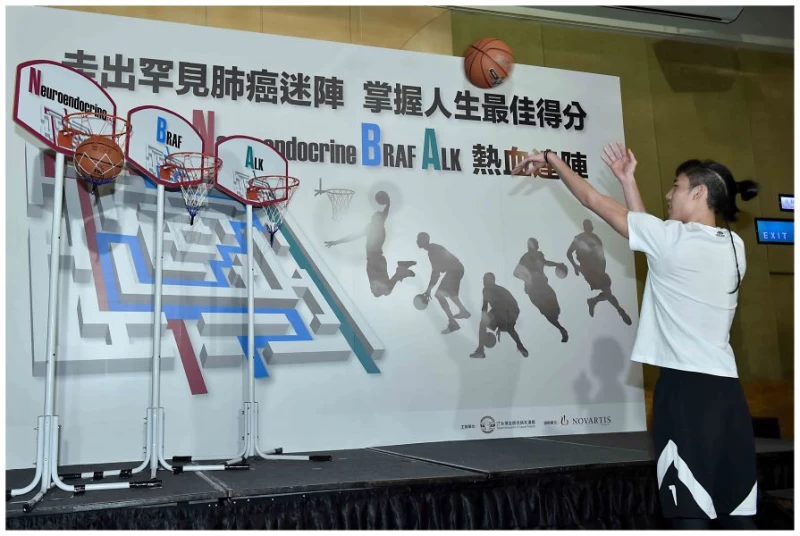 球員林書緯針對代表罕見肺癌基因型別之腫瘤籃框投籃,象徵準確治療。