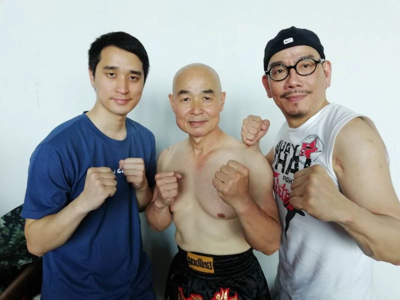 60歲高齡拳手張梓育(中)首度登台，連兒子都開始受感染學拳。大會提供