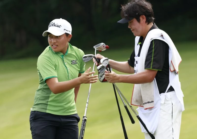 李欣兩天成績69.66以(-9)衝到第一.黃玉珍教練兼桿弟。鍾豐榮攝影