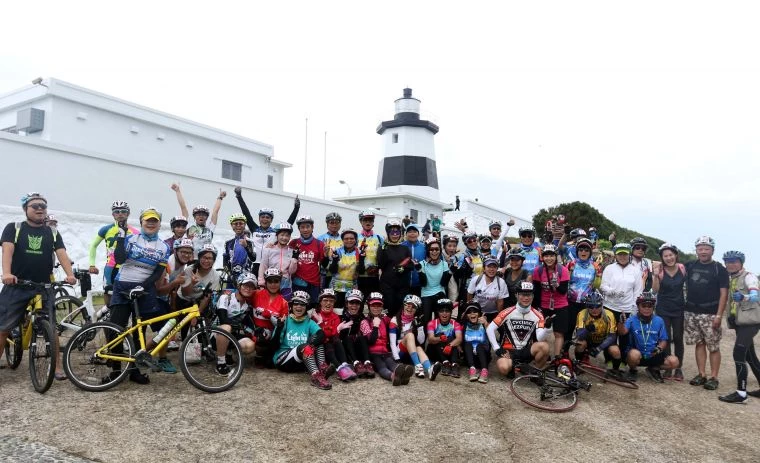 2018LightupTaiwan極點慢旅系列活動第二站,車友開心和富貴角塔合照。中華民國自行車騎士協會/提供。