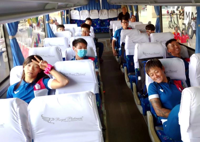 等了四個小時才搭上接駁車，自由車國手黃亭茵(左)苦中作樂比YA。楊東蓁／提供。