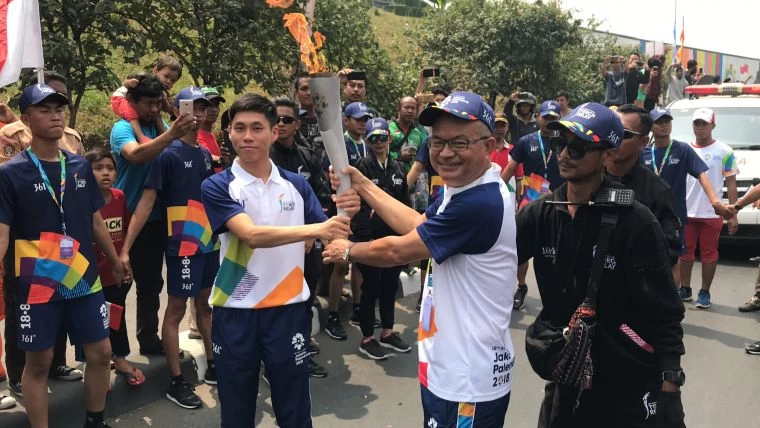 由陳秉豐(左)交棒聖火火炬給台灣摩曼頓陳文福協理(右)。361°提供