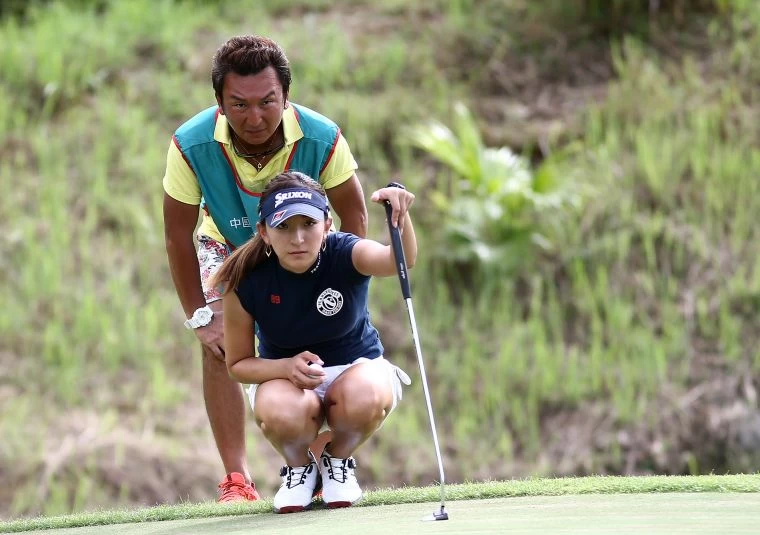 日籍選手脇元華與桿弟父親專注看著果嶺坡道。