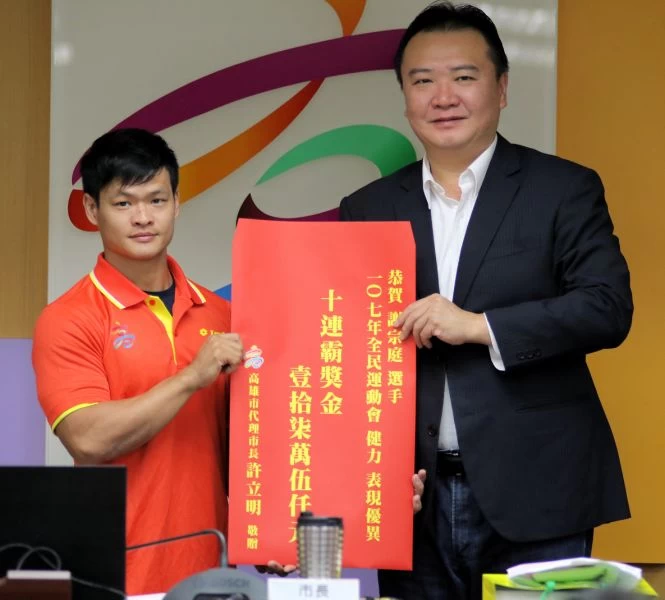 高雄市代理市長許立明頒贈健力選手謝宗庭全民運10連霸紀錄獎金。高雄市體育發展局提供
