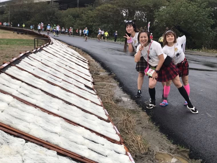 跑者與米粉大道合影留念。