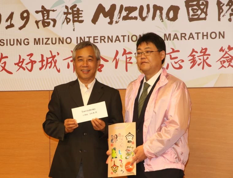 日本小山市產業觀光部田尻淳次長(右)致贈高雄市運發局代理局長周明鎮紀念品。
