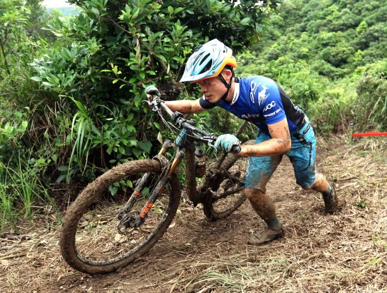 天雨場地泥濘,連江勝山也罕見地下來牽車。中華民國自由車協會/提供。