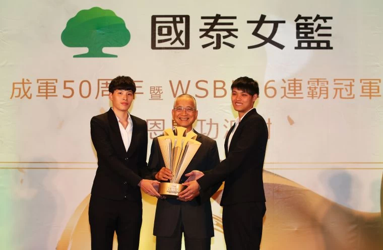 新科WSBL冠軍賽MVP林育庭(左)、鄭伊秀(右)獻冠軍盃給國泰人壽董事長黃調貴。