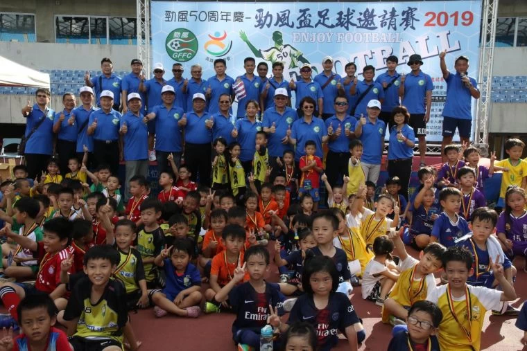 高雄市勁風足球隊在高雄國家體育場舉辦成立五十周年慶，與會來賓與參賽小朋友一起合影慶賀。高雄市府運動發展局 提供