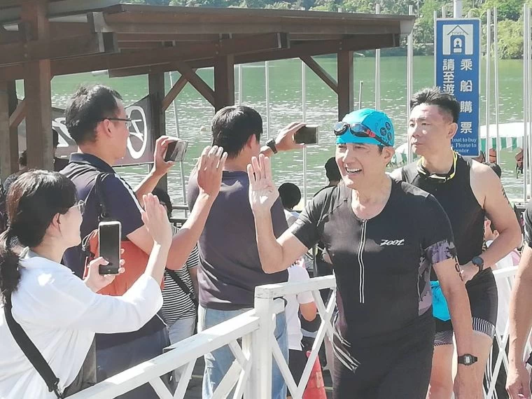 馬前總統沿路幫他加油的民眾擊掌。中華民國鐵人三項協會提供