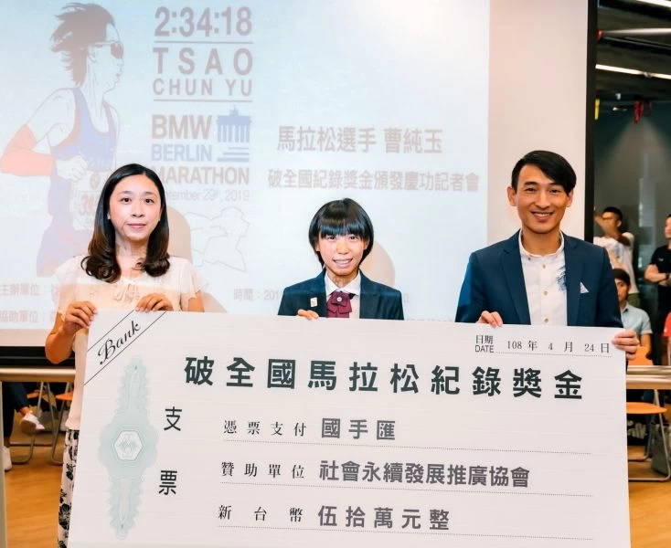 曹純玉(中)獲頒由「國手匯」提供的破馬拉松全國紀錄獎金50萬元。國手匯/提供。