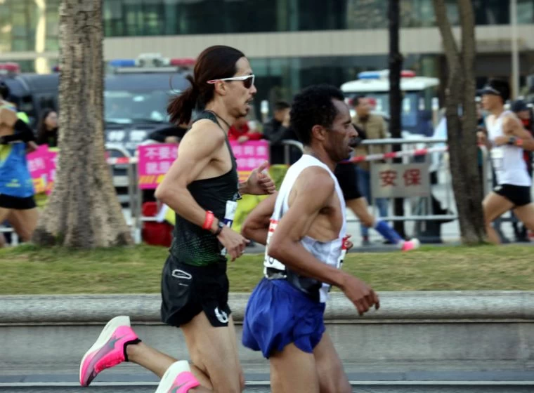 張嘉哲(左)在2019廣州馬拉松以2:15:02打破自己八年前所創的個人最佳成績2:15:56。林駿豪/提供
