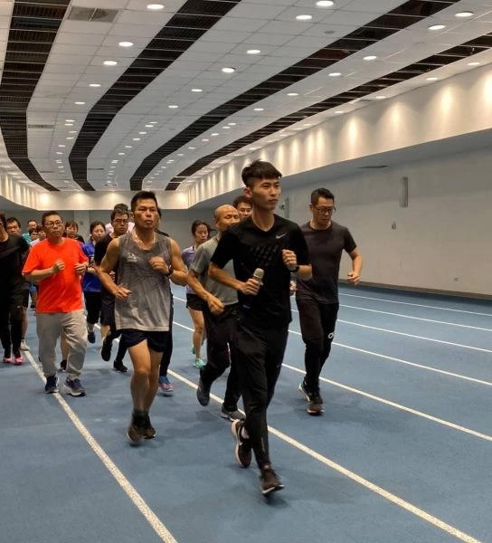 邱韋翔(手持麥克風者)於高雄國家體育場分享跑步訓練經驗,也帶動民眾們熱情投入練習。高雄市政府運動發展局提供
