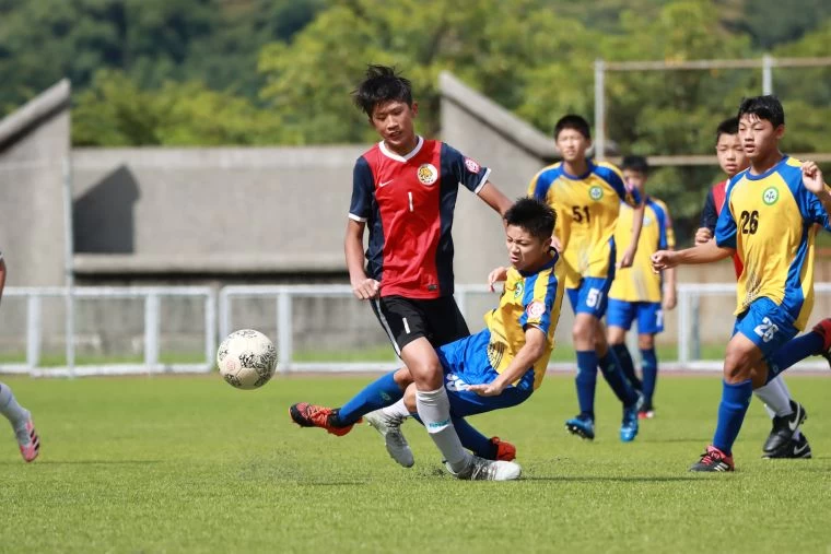 建功高中99號張皓翔與陳信安足球學校U-15許誠展碰撞激烈。大會提供