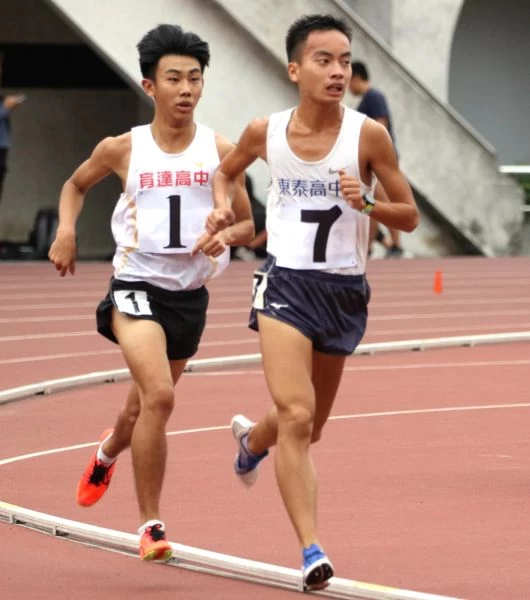 新竹縣東泰高中胡冠愷(前)在5000公尺決賽,最後一圈被桃園市育達高中黃柏憲(後)超車。林嘉欣/攝影。