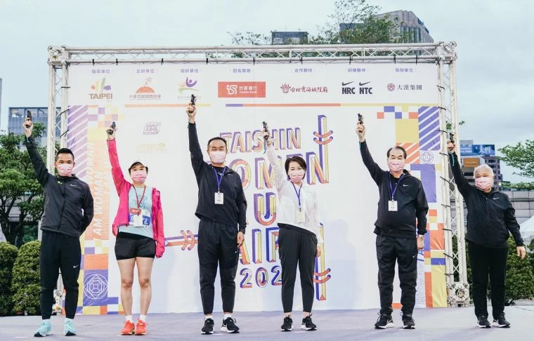 最美麗的台新女子路跑賽今天在微涼舒適的氣溫下開跑,臺北市副市長黃珊珊(右三)與台上嘉賓(左起)NRC總教練吳文騫、台新銀行環貿金融處蘇韻琇副總、臺北市政府體育局局長李再立、中華民國路跑協會理事長范姜瑞、台北霞海城隍廟管理人陳文文共同鳴槍。 路跑協會提供