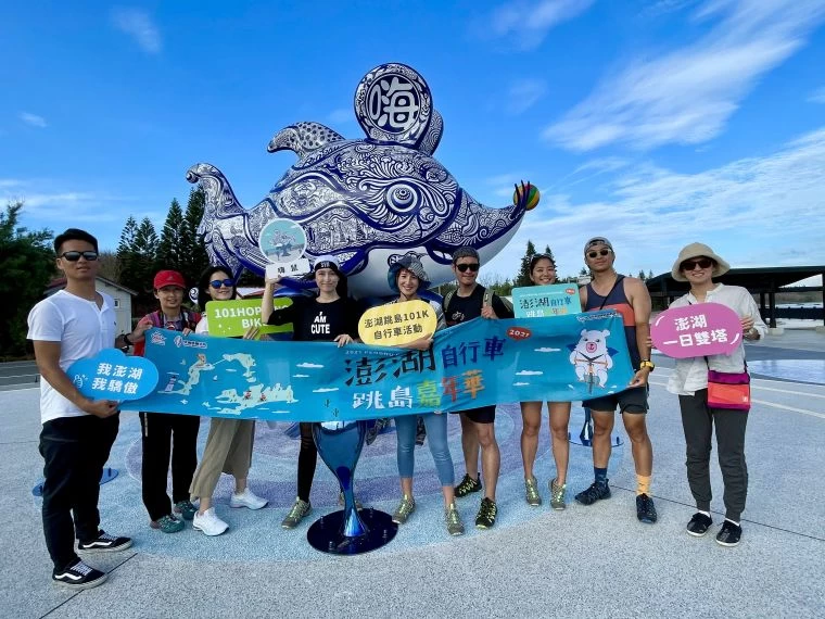 澎湖自行車跳島嘉年華辦理踩線團,由鐵人美女雙主播夏嘉璐(右五)、侯以理(右三)及土耳其裔自行車女神舒(左四)舒領軍於澎湖新地標嗨鼠前合影。官方提供