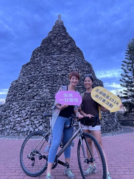 鐵人美女主播夏嘉璐(左)、侯以理(右)解鎖澎湖跳島101K一日雙塔於鎖港北塔前合影。官方提供