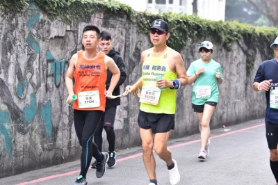 視障跑者與視障陪跑員靠手中的陪跑繩聯繫與溝通。(主辦單位提供)
