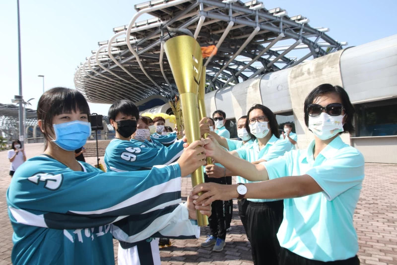 高雄市滑輪溜冰長桿曲棍球女子組隊員與嘉義縣全民運動會聖火隊進行聖火交接儀式。 高雄市政府運動發展局提供